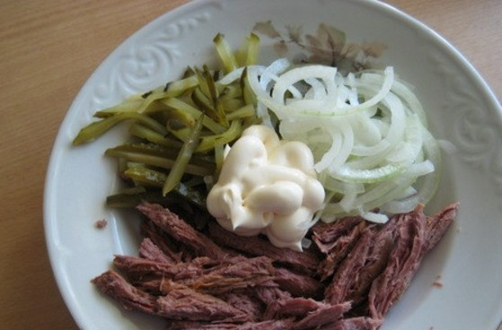 1. Этап. Салат Лист папоротника: 5. Отожмите лук от жидкости и переложите в миску, добавьте к нему мясо, огурцы, майонез, соль.