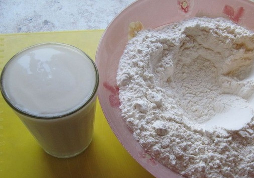 1. Этап. Тесто для вареников на пару на кефире: Муку пшеничную высшего сорта просейте в миску два раза, чтоб она насытилась кислородом. Затем сделайте в ней углубление. Разогрейте кефир так, чтобы он был еле теплый.