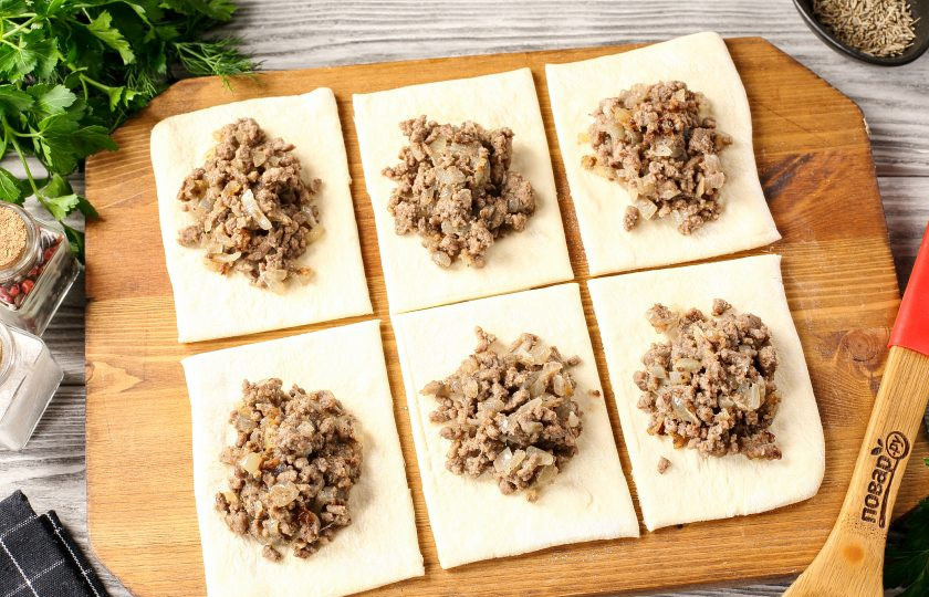 1. Этап. Жареная слоёная самса с мясом: Каждый кусок теста раскатайте в прямоугольный пласт, толщиной приблизительно 5 мм. Поделите на 6 частей. По центру выложите начинку, тесто вокруг начинки смажьте яичным белком и сформируйте самсу любой удобной формы.
