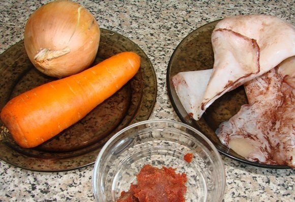 1. Этап. Солянка из морской капусты: Подготовим ингредиенты. Для начала отварим кальмары. Доводим до кипения воду в небольшой кастрюльке, забрасываем в нее тушки кальмаров, ждем 2 минуты — и выключаем огонь. Накрываем крышкой, ждем еще 10 минут. После этого выкладываем кальмары на тарелку.