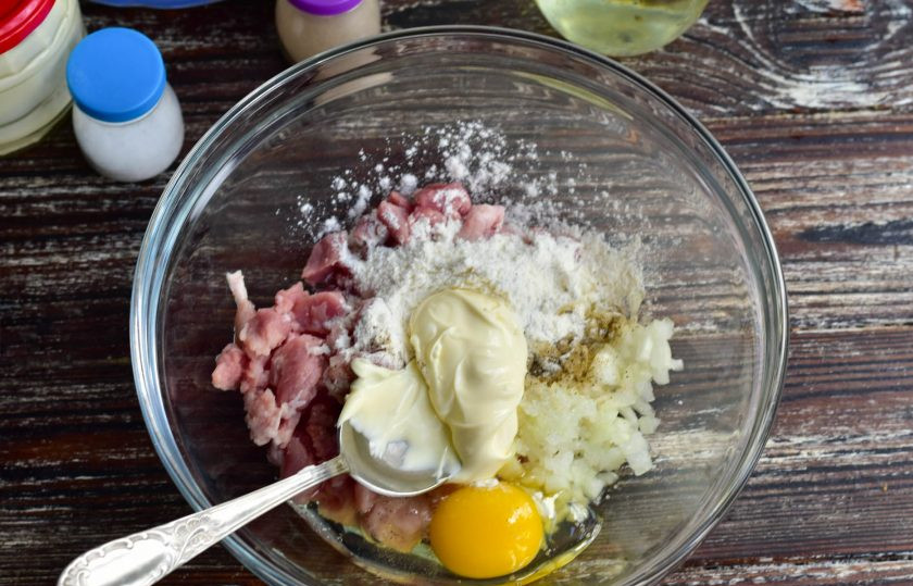 1. Этап. Оладьи из рубленой свинины: Выложите в миску нарезанные ингредиенты, добавьте соль, перец, муку, майонез. Вбейте яйцо.
