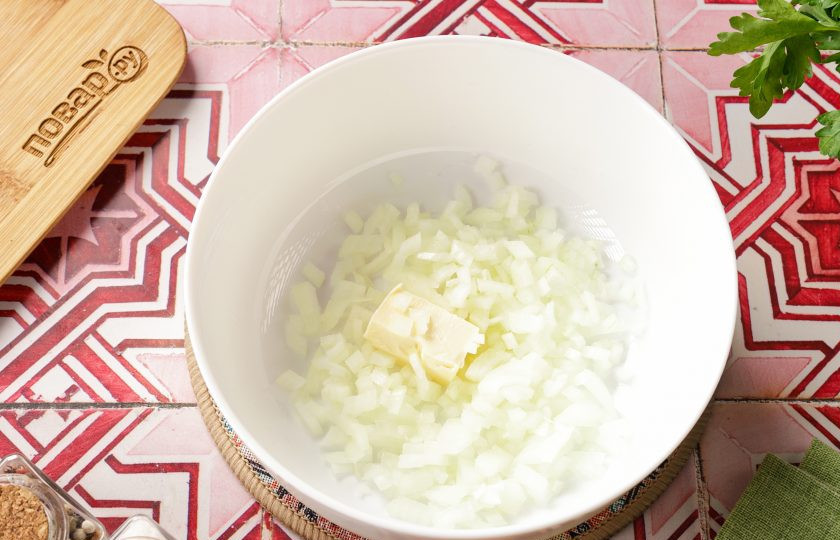 1. Этап. Печень в микроволновке: Нарежьте лук мелкими кубиками. В любую глубокую, подходящую для СВЧ ёмкость, выложите лук и добавьте кусочек сливочного масла. Поставьте в микроволновку на 3 минуты, мощность 800 вт.