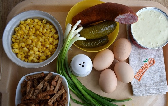 1. Этап. Салат Иришка с сухариками: Подготовьте необходимые ингредиенты. Отварите яйца, сухарики высыпьте из пакета. Отложите несколько для украшения. Кукурузу слейте и откиньте на сито. Лук промойте.