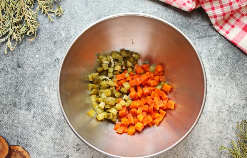 1. Этап. Винегрет с мидиями: Морковь почистите и порежьте средним кубиком, выложите в салатник. Соленый огурец порежьте средним кубиком и добавьте к моркови.