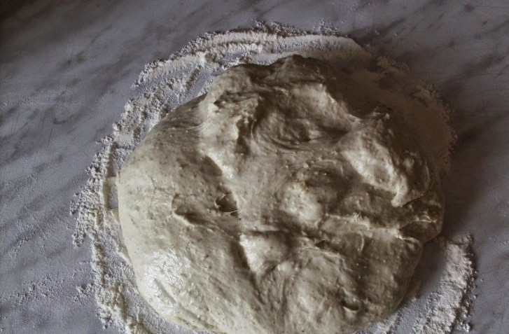 1. Этап. Постный бездрожжевой хлеб: По прошествии суток возьмите большую миску и положите туда 2 ст. ложки закваски, всыпьте коричневый сахар, соль, налейте 100 мл тёплой воды и просейте около 250 граммов муки. Вымешайте тесто, сделав его однородным.