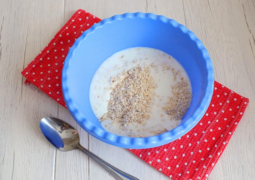 1. Этап. Овсяные блины на кефире: Пересыпьте овсянку в глубокую чашу, залейте кефиром комнатной температуры.