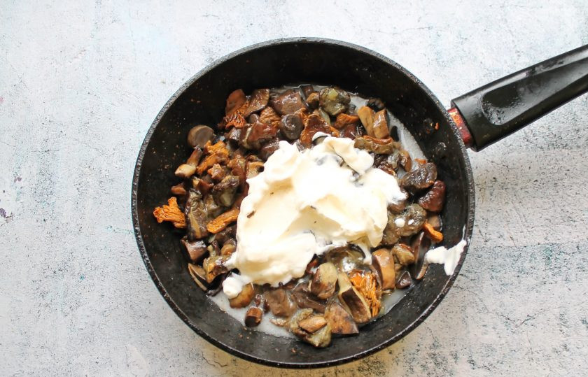 1. Этап. Грибы на сковороде со сметаной и сыром: В сковороду добавьте сметану, влейте горячую воду, посолите и поперчите. Тушите все еще 5 минут.