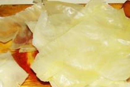 1. Этап. Голубцы с грибами: 1. Приготовим капустные листья. Для этого снять с вилка верхние листья, удалить кочерыжку. В кастрюле вскипятить воду, посолить ее и опустить туда вилок. Проварить на маленьком огне минуты 3-4. Вилок размягчится. Аккуратно снять с него листья и срезать утолщения.