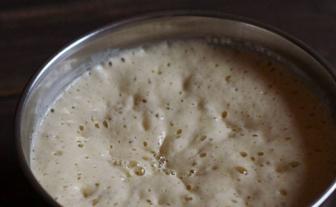 1. Этап. Оладушки на дрожжах и молоке: Снова накройте миску пищевой пленкой и отправьте в тепло на сорок минут. Затем, когда тесто подойдет и увеличится вдвое, перемешайте его.