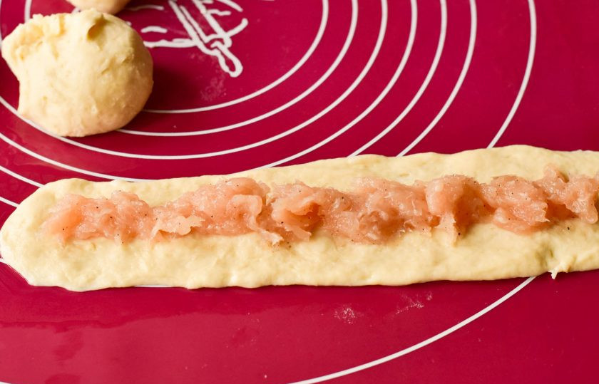 1. Этап. Мясные кольца в духовке: Обомните поднявшееся тесто, разделите его на 5-7 частей. Каждый раскатайте в колбаску и придавите ее. Выложите начинку из мясного фарша.