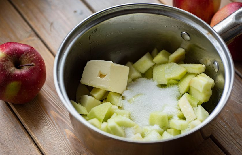 1. Этап. Насыпной пирог с яблоками без манки: В сотейник выложите яблоки, добавьте 60 грамм сахара и 30 грамм сливочного масла.