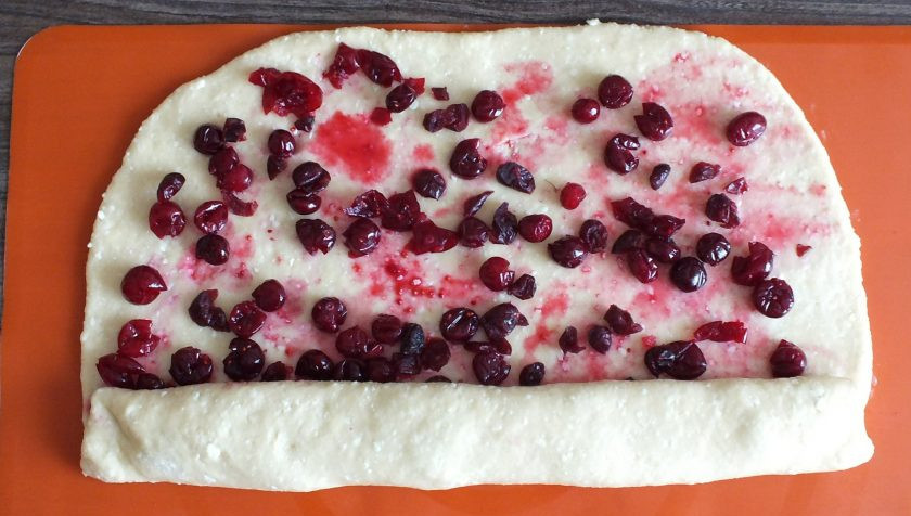 1. Этап. Творожный рулет с клюквой: Подготовленный пласт теста с начинкой, начните закручивать в пласт с длинной стороны. Закручивайте как можно туже.