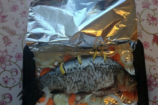 1. Этап. Карась в фольге в духовке: 7. Подготовьте лист фольги и выложите его на противень. Смажьте немного растительным маслом. Выложите рыбку и овощи, если не все влезли в брюшко. Заверните конверт из фольги и отправьте противень в духовку минут на 20. После аккуратно снимите фольгу и подрумяньте рыбку в духовке еще минут 5-7.