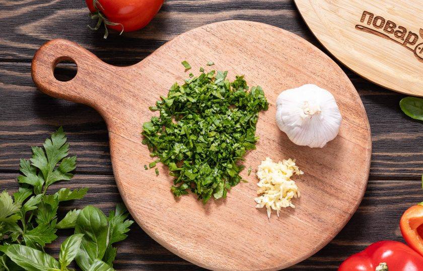 1. Этап. Аджапсандал с баклажаном и чесноком: Кинзу, зеленый базилик и петрушку мелко порубите. Чеснок натрите на мелкой терке или пропустите через пресс.