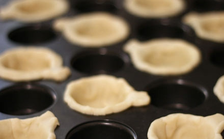 1. Этап. Тыква для детей: 3. Аккуратно прижмите тесто ко дну и сторонам. Разбейте 1 яйцо и отделите белок от желтка. Смажьте формочки белком.