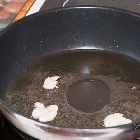 1. Этап. Овощи в кисло-сладком соусе с кешью: В сковороде разогреваем масло, обжариваем в нем немного раздавленные зубчики чеснока.