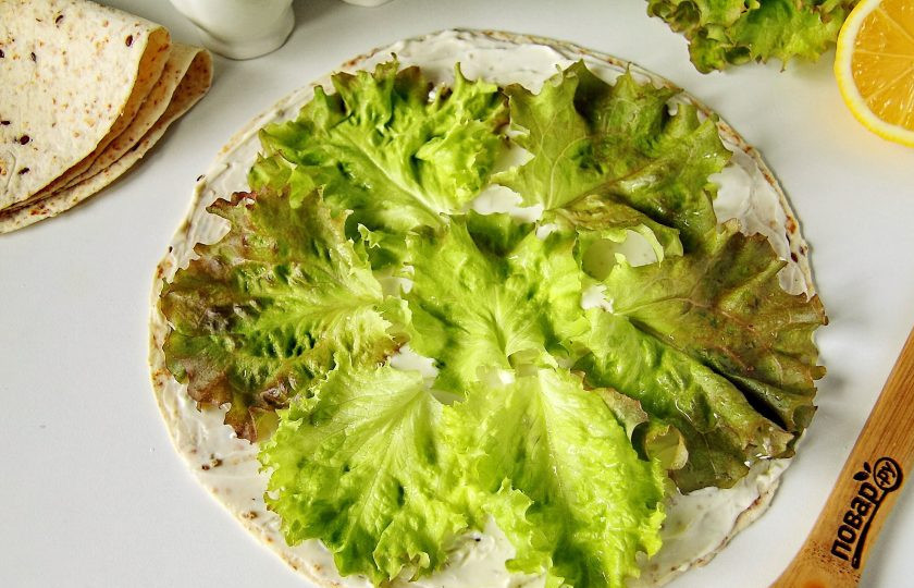 1. Этап. Ролл с сыром и ветчиной: Смажьте лаваш сливочным сыром и разложите на нем листья салата. Салат предварительно необходимо промыть и обсушить.