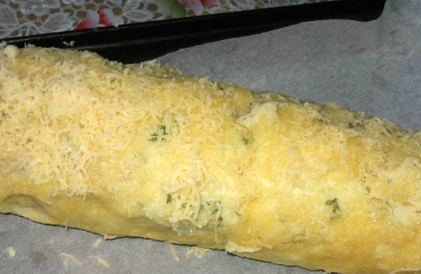 1. Этап. Мясной рулет в картофельной оболочке: Далее вынимаем рулет, разворачиваем и посыпаем тертым сыром. Выкладываем на противень, смазанный маслом. Выпекаем при температуре 200 градусов в течение пятнадцати минут.