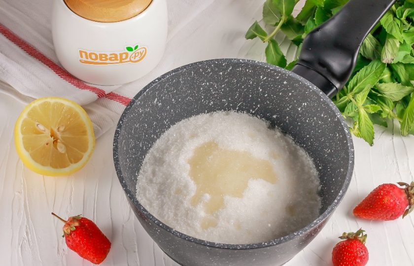 1. Этап. Целая клубника с сахаром на зиму: Высыпьте сахар в ковш или в казан с антипригарным дном. Влейте лимонный сок. Его добавлять нужно обязательно, чтобы сахар не кристаллизировался при варке и чтобы подчеркнуть вкус лакомства.