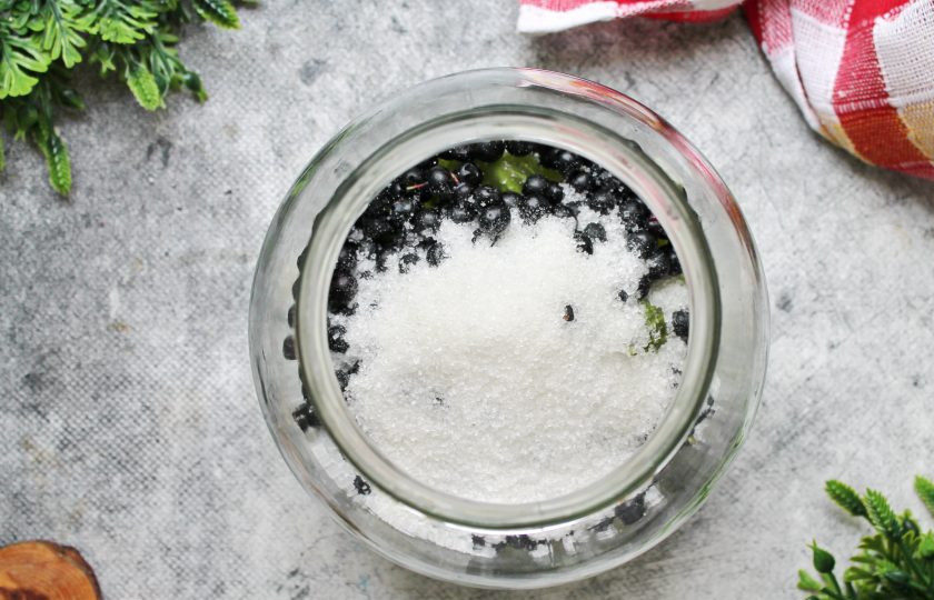 1. Этап. Настойка из черники с крыжовником на самогоне: Всыпьте сахар в банку с ягодами.