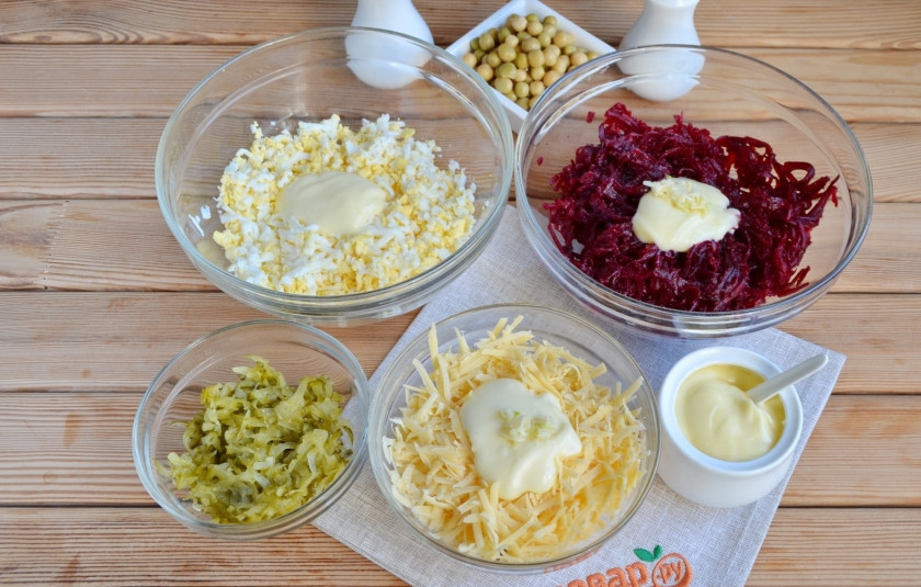 1. Этап. Салат Простушка: Свеклу натрите на крупной терке, добавьте соль, 2 зубчика чеснока и майонез, перемешайте. Натрите сыр на крупной терке, добавьте 1 зубчик чеснока, майонез, перемешайте. Натрите на терке яйца, добавьте щепотку соли, майонез, перемешайте. Огурцы тоже следует натереть на терке, отожмите лишнюю влагу.