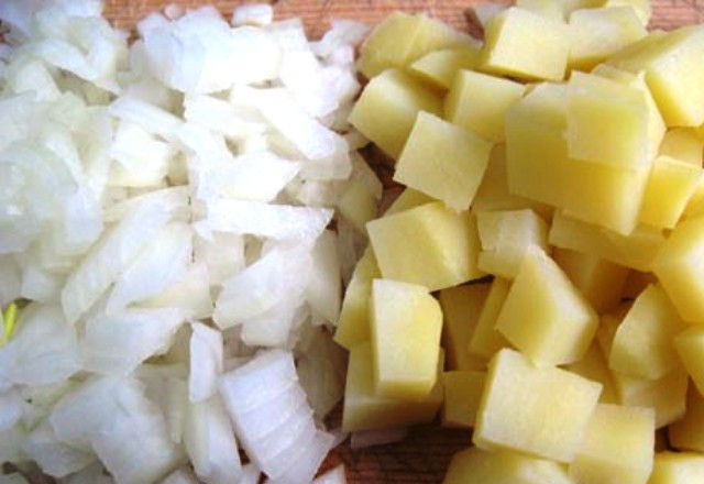 1. Этап. Простой салат из печени трески: Картофель отварите в кожуре, затем очистите и нарежьте кубиками. Также измельчите лук.