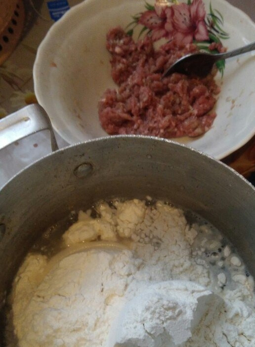 1. Этап. Пельмени из говяжьего фарша с луком: 2. Тесто также каждый использует любое. Я предпочитаю на горячей воде — проверенный вариант. Итак, в горячую воду добавляем соль и всыпаем муку. Замешиваем быстро тесто, поскольку оно сразу заваривается.