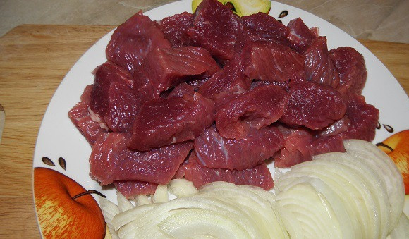 1. Этап. Гуляш со сливками: Мясо нарезаем на небольшие кусочки. Чистим лук и нарезаем полукольцами.