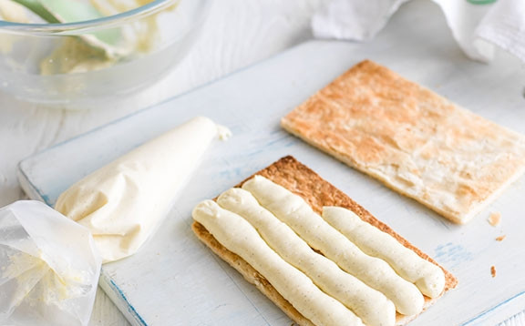 1. Этап. Сливочный мильфей: 4. С помощью кондитерского шприца начините коржи кремом.