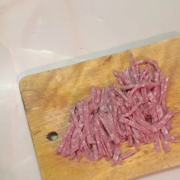 1. Этап. Салат Любавушка: Копченую колбасу и ветчину или отварное мясо нарезать соломкой и выложить в миску с луком.