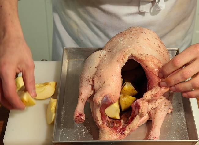 1. Этап. Запеченный гусь, фаршированный яблоками: Гуся натрите тмином, солью, сухим майораном и нафаршируйте яблоками.