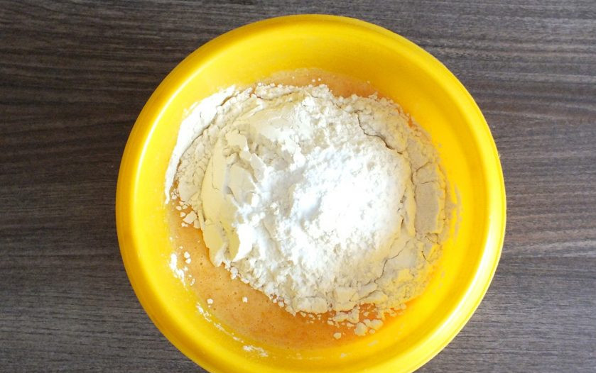 1. Этап. Тыквенное печенье с клюквой: Добавьте муку, соду, ванилин. Начните замешивать тесто с помощью ложки.