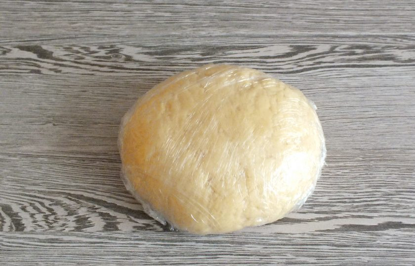 1. Этап. Сочни на маргарине: Готовое тесто имеет мягкую, податливую консистенцию. Оно может незначительно липнуть к рукам. Оберните тесто пищевой плёнкой и уберите в холодильник на 40 минут.