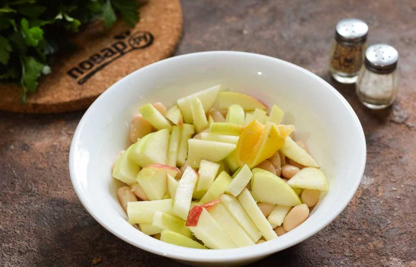 1. Этап. Салат с тунцом, яблоком и фасолью: Яблоко очистите и нарежьте дольками. При желании яблоки можно сбрызнуть лимонным соком.