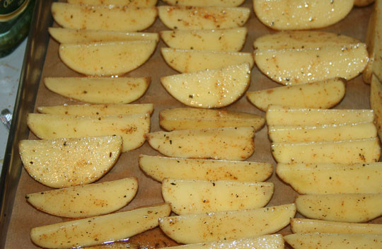 1. Этап. Картошка по-деревенски с мясом: Для начала замаринуйте мясо в смеси из соли, перца, оливкового масла, майорана. Оставьте его на 15 минут. Тем временем картофель моем, очищаем и нарезаем дольками. Выкладываем его на противень, застеленный пекарской бумагой. Смазываем оливковым маслом и присыпаем специями. Запекаем 25 минут при температуре 180 градусов.