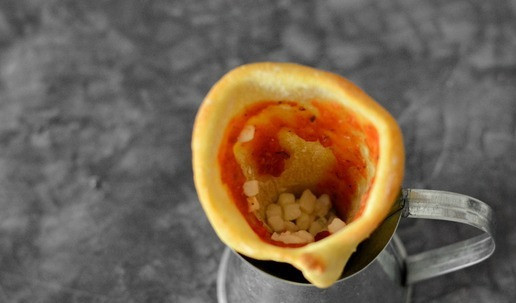 1. Этап. Коно пицца: Установите рожок теста вертикально в стакан. Смажьте внутри ложкой соуса, а в основание рожка насыпьте примерно 1 чайную ложку моцареллы.