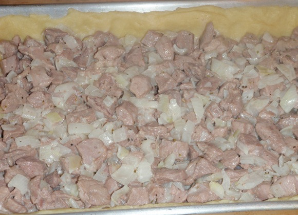 1. Этап. Вкусный пирог с мясом: Выкладываем на тесто начинку, распределяем ее ровным слоем.