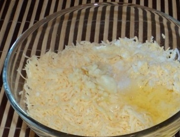 1. Этап. Слоеный сырный пирог: Добавить белок сырого яйца и измельченный чеснок. Если ваш сыр не слишком соленый, добавьте щепотку соли. Перемешайте.