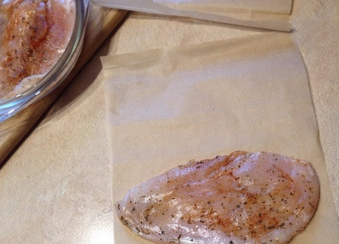 1. Этап. Куриные грудки отбивные: А теперь самое интересное. Вырезаем из пергамента 2 листа размером в два раза больше размера филе. Выкладываем одну куриную отбивную на край листа и накрываем свободным краем пергамента.