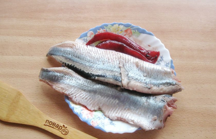 1. Этап. Калалаатикко: Мороженую сельдь разморозьте. Удалите голову и плавники. Разрежьте на две части вдоль и достаньте хребет. Уберите крупные кости. Должно получиться два филе.