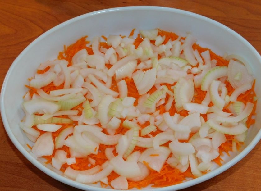 1. Этап. Рыба с овощами под сыром: Лук крупно нарежьте и разложите следующим слоем по моркови.