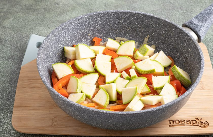1. Этап. Булгур с кабачками, сладким перцем и фасолью: Кабачок нарежьте четвертинками, добавьте в сковороду и готовьте с остальными овощами еще 2-3 минуты.