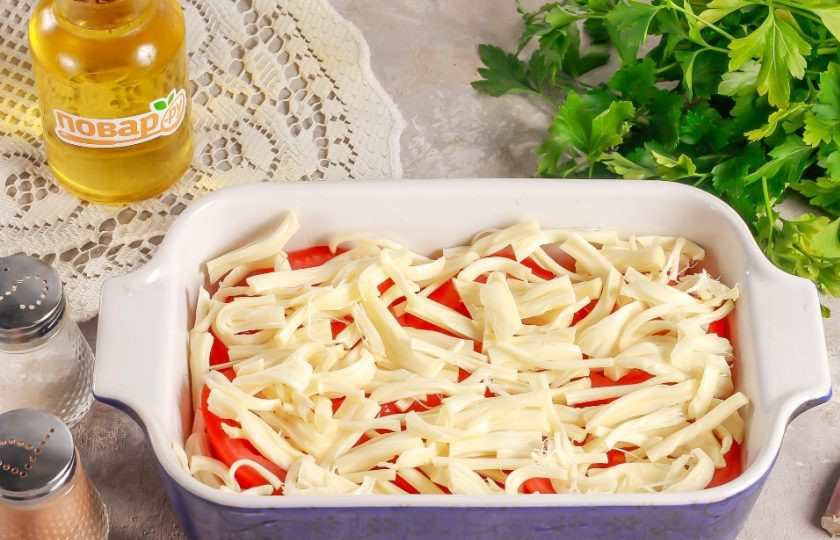 1. Этап. Помидоры запечённые с сыром сулугуни и чесноком: Нарежьте сыр полосками или брусочками и выложите на слой томатов в емкости.