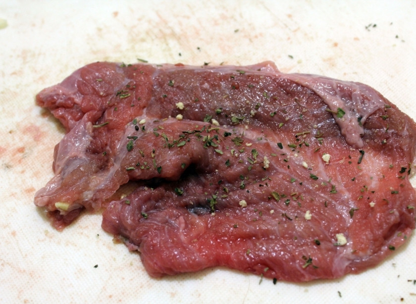 1. Этап. Рулетики из говядины с начинкой: Разрежьте её на несколько частей и очень тонко отбейте. Высотой не больше 0,5 см. Посолите её. Приправьте сушёной петрушкой.