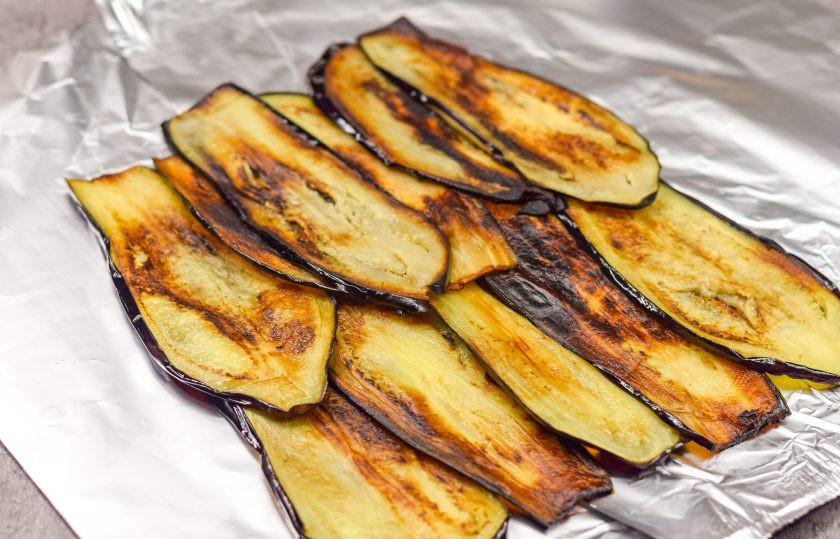 1. Этап. Рулет из баклажан, яиц и ветчины: Баклажаны выложите на фольгу или пищевую пленку, внахлест, в два ряда.