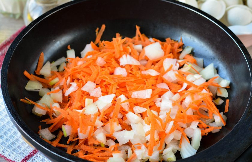 1. Этап. Пельмени тушеные с морковью и луком: Разогрейте масло на сковороде, всыпьте лук и морковь.