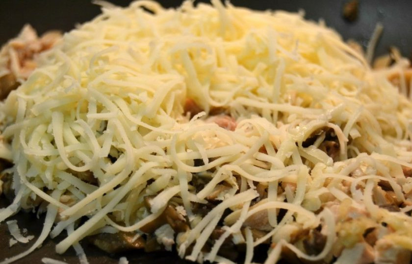 1. Этап. Фаршированный авокадо в духовке: 10. Добавьте тертый сыр, соль и перец по вкусу, перемешайте.