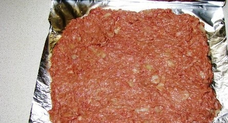 1. Этап. Мясной рулет с картофелем: Расстелите фольгу на столе, выложите на неё фарш, придайте ему форму прямоугольного пласта. Включите духовку разогреваться до 180 градусов.