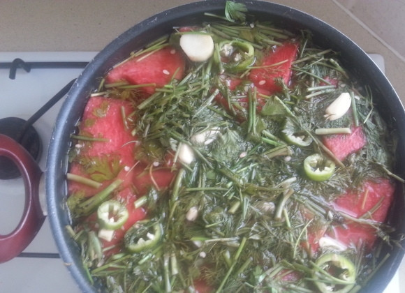 1. Этап. Маринованные арбузы в банках: Арбуз с зеленью нужно залить рассолом из уксуса, сахара и соли. Чтобы заполнить кастрюлю доверху жидкостью, долейте да краёв кастрюли холодной кипячёной воды. Полученный арбуз в маринаде нужно выдержать около 1,5 суток. Время от времени содержимое кастрюли нужно аккуратно перемешивать деревянной ложкой.