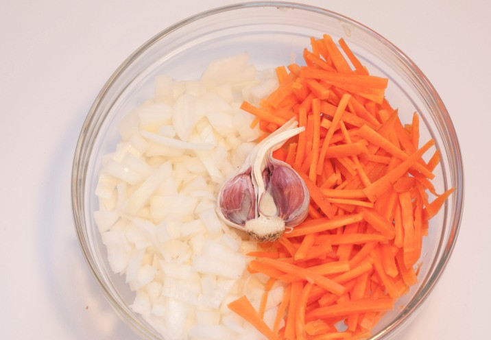 1. Этап. Баранина с рисом в мультиварке: Очищаем и промываем овощи, репчатый лук нарезаем мелко, а морковь режем соломкой. Берем где-то половину головки чеснока, чеснок чистить не нужно, просто снимаем с него верхний слой шелухи.